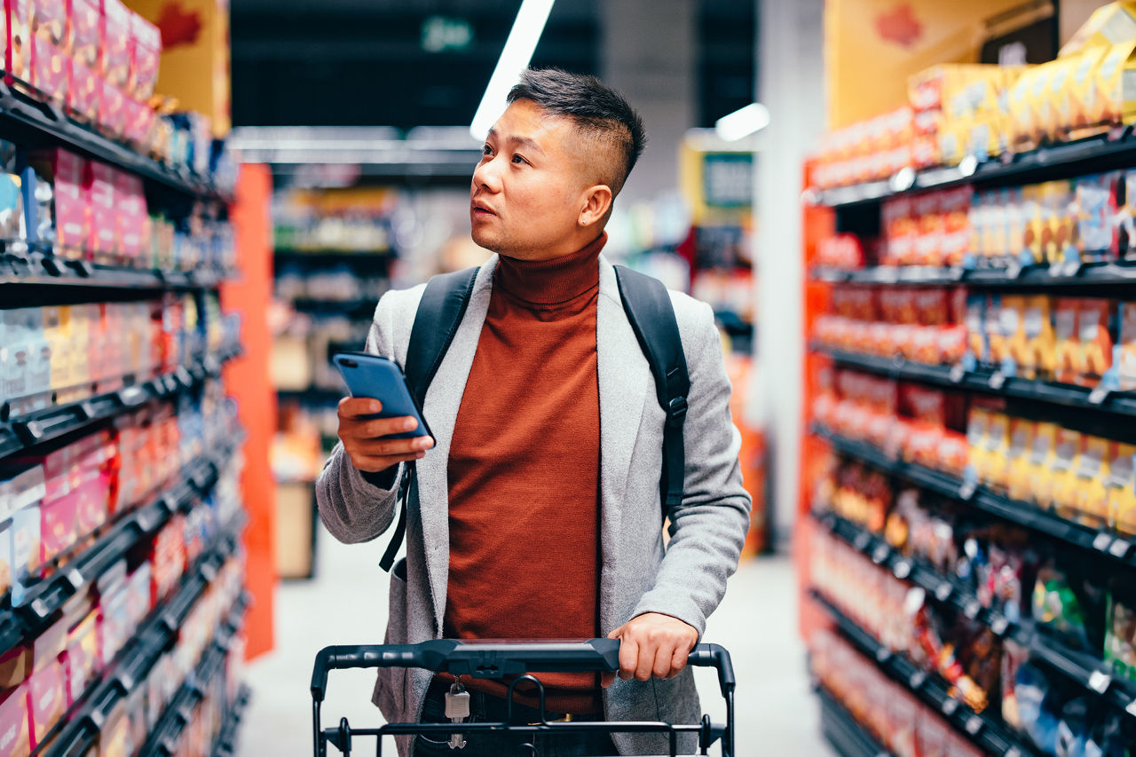 Persoon die bij Colruyt boodschappen doet met de Xtra-app.